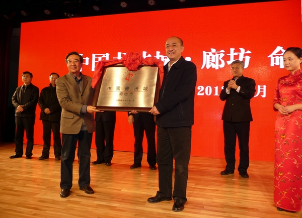 聂瑞平(右)从旭宇手中接过廊坊中国书法城铜匾 一超摄